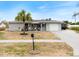 Well-maintained single-Gathering home featuring a light blue front door, garage and mature palm tree at 6531 Marius Rd, North Port, FL 34287