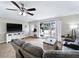 Bright living room with wood floors, a large window, a ceiling fan, comfortable seating, and entertainment center at 6531 Marius Rd, North Port, FL 34287