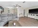 Spacious living room with wood floors, comfortable seating, entertainment center, and seamless access to the dining area at 6531 Marius Rd, North Port, FL 34287