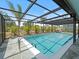 Enclosed outdoor pool, enhanced by a stone patio, promising relaxation and entertainment in a tropical setting at 6531 Marius Rd, North Port, FL 34287