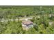 Aerial view of the charming home with screened pool surrounded by lush, tall trees at 7135 Tropicaire Blvd, North Port, FL 34291