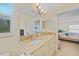 A bathroom features a vanity with double sinks, granite countertops, with access to the primary bedroom at 7135 Tropicaire Blvd, North Port, FL 34291
