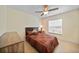 This bedroom offers neutral colors, light tile floors, ceiling fan and a window with natural light at 7135 Tropicaire Blvd, North Port, FL 34291
