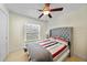 This bedroom offers neutral colors, light tile floors, a gray headboard, and a window with natural light at 7135 Tropicaire Blvd, North Port, FL 34291
