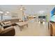 Spacious open-concept living area with tile flooring, a ceiling fan, and seamless flow to the kitchen at 7135 Tropicaire Blvd, North Port, FL 34291