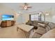 Comfortable living room featuring tile flooring, a ceiling fan, and ample natural light at 7135 Tropicaire Blvd, North Port, FL 34291