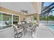 Relaxing screened patio with ceiling fan and outdoor dining set overlooking a sparkling pool at 7135 Tropicaire Blvd, North Port, FL 34291