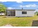 Backyard view showcases a screen porch and a spacious grassy area at 815 Papaya Dr, Tampa, FL 33619