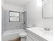 Well-lit bathroom features a marble tiled shower, toilet, and vanity with sink at 815 Papaya Dr, Tampa, FL 33619