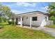 Cozy home with a covered front porch and driveway nestled on a grassy lot at 815 Papaya Dr, Tampa, FL 33619