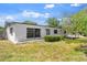 Quaint white home with a covered entry, security bars, and a lush green lawn at 815 Papaya Dr, Tampa, FL 33619