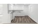 Modern kitchen with white cabinets, countertops, and sleek wood-look flooring at 815 Papaya Dr, Tampa, FL 33619