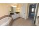Bright bathroom showcasing soaking tub, large mirror, and tiled floors at 99 Vivante Blvd # 311, Punta Gorda, FL 33950