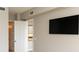 A simple bedroom with a door to a kitchen and a mounted flat screen TV at 99 Vivante Blvd # 311, Punta Gorda, FL 33950