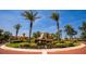 Beautiful community entrance showcasing palm trees, landscaping, and building architecture under a clear blue sky at 99 Vivante Blvd # 311, Punta Gorda, FL 33950