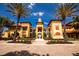 Stunning building featuring a red-tiled roof, symmetrical architecture, and lush landscaping with palm trees at 99 Vivante Blvd # 311, Punta Gorda, FL 33950