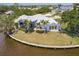 Aerial view of waterfront home with mature tropical landscaping and enclosed lanai at 12439 Prather Ave, Port Charlotte, FL 33981