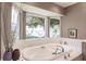 Bathroom featuring a large soaking tub with jets, and a window overlooking the lush landscaping at 12439 Prather Ave, Port Charlotte, FL 33981