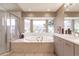 Bathroom featuring a tub, shower and a large window overlooking the lush landscaping at 12439 Prather Ave, Port Charlotte, FL 33981