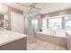 Bathroom featuring a tub, shower and a large window overlooking the lush landscaping at 12439 Prather Ave, Port Charlotte, FL 33981