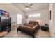 Cozy bedroom featuring a queen bed with a dark brown comforter, complemented by a ceiling fan at 12439 Prather Ave, Port Charlotte, FL 33981