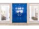 Close-up of a vibrant blue double door, flanked by sidelights and decorative plants at 12439 Prather Ave, Port Charlotte, FL 33981