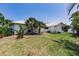 View of the exterior with healthy green grass, palm trees, and crisp, white walls at 12439 Prather Ave, Port Charlotte, FL 33981