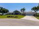 Charming one-story home featuring lush landscaping, palm trees, and a concrete driveway at 12439 Prather Ave, Port Charlotte, FL 33981