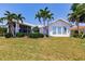 Charming single-story home boasting lush green lawn, vibrant landscaping, and a screened-in porch at 12439 Prather Ave, Port Charlotte, FL 33981