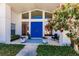 Inviting entryway with a striking blue double door framed by decorative plants and sidelight windows at 12439 Prather Ave, Port Charlotte, FL 33981