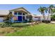 Beautiful home with a vibrant blue double-door entry and well-maintained landscaping at 12439 Prather Ave, Port Charlotte, FL 33981