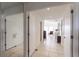 Bright hallway featuring neutral tile flooring, white walls, and multiple doorways leading to other rooms of the home at 12439 Prather Ave, Port Charlotte, FL 33981