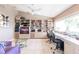 Bright home office space featuring custom shelving, a large window, and two work stations at 12439 Prather Ave, Port Charlotte, FL 33981