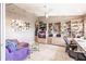 A spacious home office featuring custom shelving, a large window, a purple sofa, and a glass coffee table at 12439 Prather Ave, Port Charlotte, FL 33981