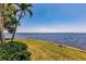 Open water view from waterfront lot with grass and tropical landscaping at 12439 Prather Ave, Port Charlotte, FL 33981