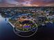 Stunning dusk aerial of a waterfront home with a private boat dock, lush landscaping and an inviting pool at 1255 Eider Ct, Punta Gorda, FL 33950