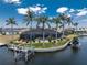 Waterfront home with screened lanai, pool, private boat dock and lift, surrounded by palm trees at 1255 Eider Ct, Punta Gorda, FL 33950