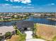 Gorgeous aerial view of a waterfront home featuring a private dock, boat lift, and tropical landscaping at 1255 Eider Ct, Punta Gorda, FL 33950