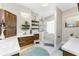 Bright bathroom featuring double vanities with wood cabinets, a round mirror, and a walk-in shower at 1255 Eider Ct, Punta Gorda, FL 33950
