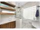 Stylish shower with marble surround, glass block window, and floating wood shelves at 1255 Eider Ct, Punta Gorda, FL 33950