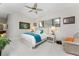 Well-lit bedroom with a ceiling fan, side tables, and a recliner chair for comfortable seating at 1255 Eider Ct, Punta Gorda, FL 33950