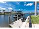 View of the private boat dock with a pontoon boat, seating, and waterfront views at 1255 Eider Ct, Punta Gorda, FL 33950