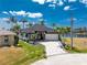Beautiful waterfront home features a manicured lawn, brick driveway, and lush tropical landscaping at 1255 Eider Ct, Punta Gorda, FL 33950