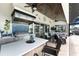 Outdoor kitchen with stainless steel grill, bar seating, and blue tile backsplash on the screened lanai by the pool at 1255 Eider Ct, Punta Gorda, FL 33950