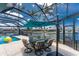 Outdoor dining area with a teal umbrella overlooking the pool and scenic waterway views at 1255 Eider Ct, Punta Gorda, FL 33950
