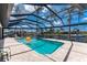 Inviting screened-in pool with a hot tub and canal views, surrounded by lush landscaping at 1255 Eider Ct, Punta Gorda, FL 33950