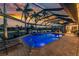 Evening view of the lit pool and spa in a screened enclosure with outdoor seating at 1255 Eider Ct, Punta Gorda, FL 33950