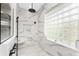 Marble tiled shower area with black hardware and a glass block window at 1255 Eider Ct, Punta Gorda, FL 33950