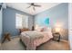 Serene bedroom featuring soft blue walls, a comfortable bed, and natural light from the window at 14051 Heritage Landing Blvd # 536, Punta Gorda, FL 33955