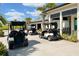 Golf carts parked outside of a building with palm trees in the background at 14051 Heritage Landing Blvd # 536, Punta Gorda, FL 33955